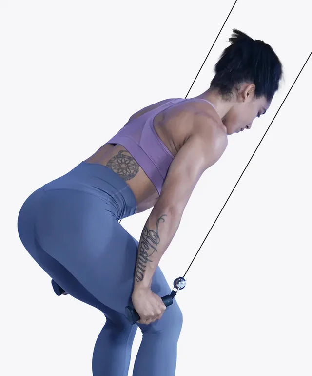 A woman bending forward and pulling a cable handle
